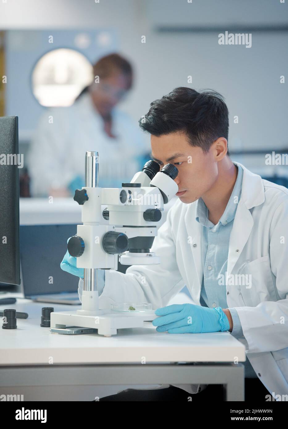 Pas mieux que maintenant. Un jeune technicien d'analyse d'échantillons à l'aide d'un microscope. Banque D'Images