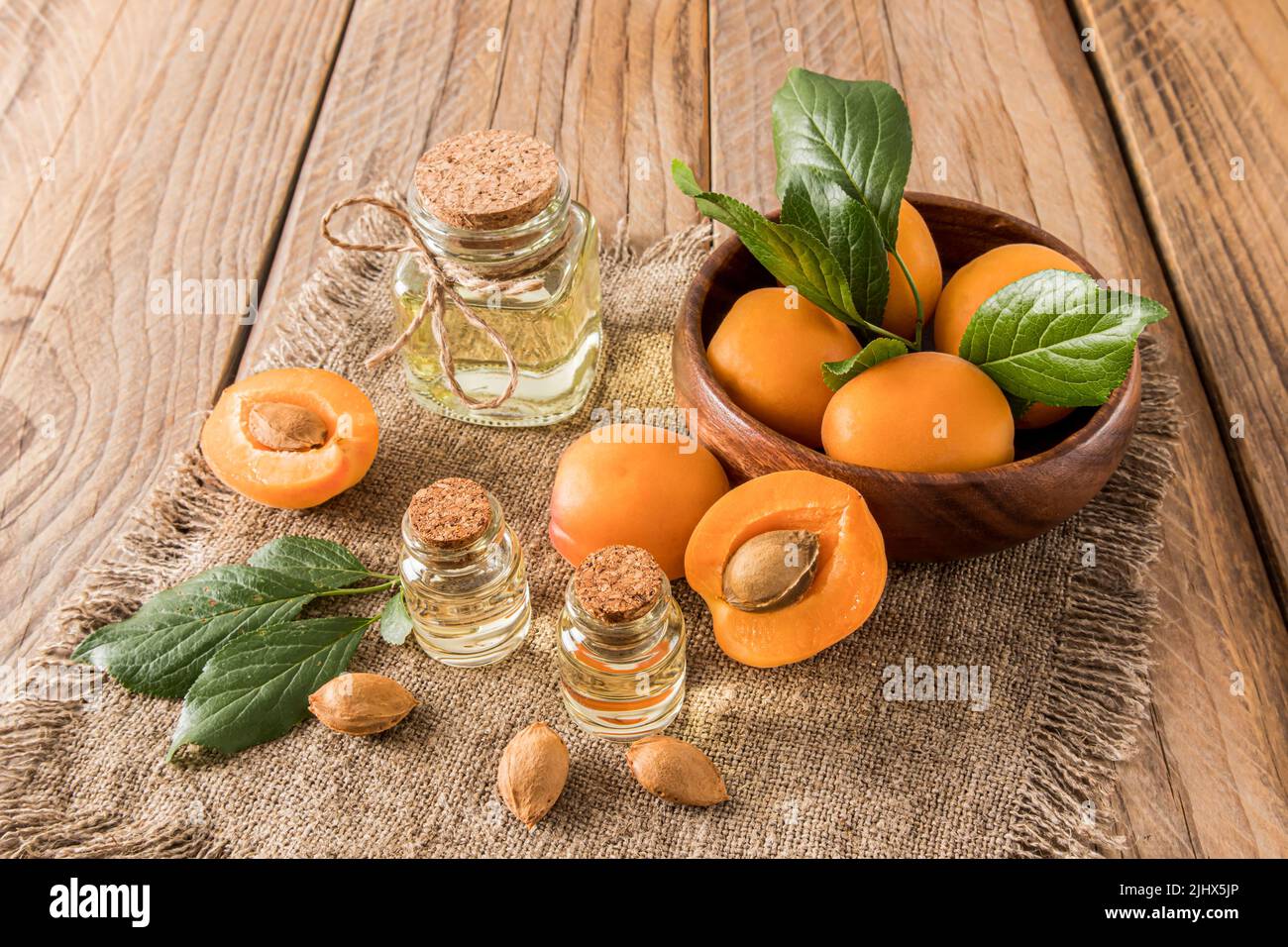 bol en bois avec bouteilles en verre et couvercle en liège huile d'abricot pour le soin du visage et du corps. produit naturel et biologique de cosmétiques. fond rustique Banque D'Images