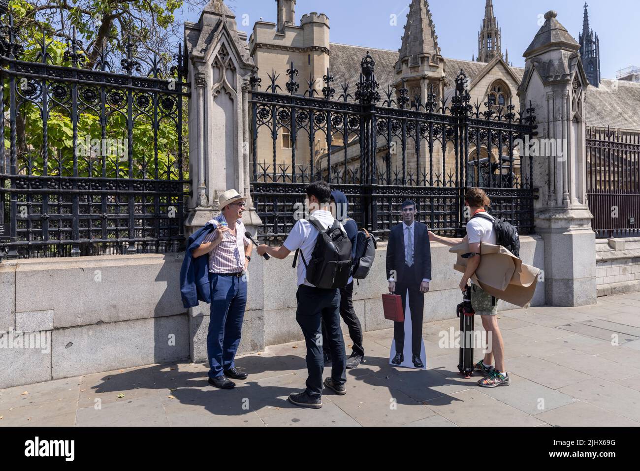 Des journalistes ont interviewé un piéton dans la rue devant le Parlement tout en portant un carton de la taille de Rishi Sunak, Londres, Royaume-Uni Banque D'Images