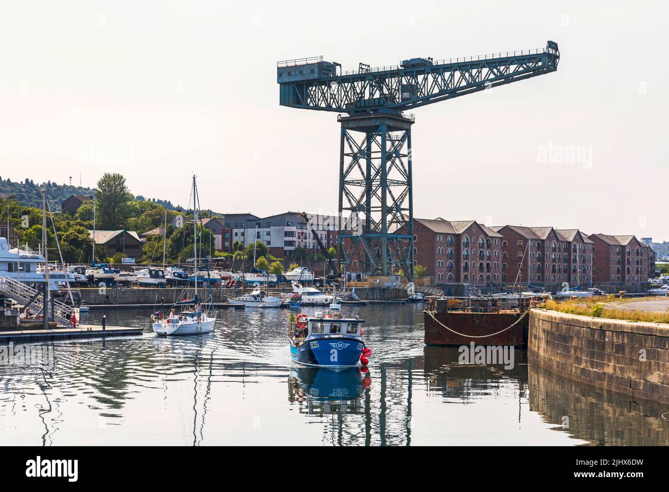 Port de plaisance James Watt, avec des yachts à quai et la grue de chantier naval en porte-à-faux au loin, bateau de pêche local approchant de la jetée, Port Glasgow. Banque D'Images