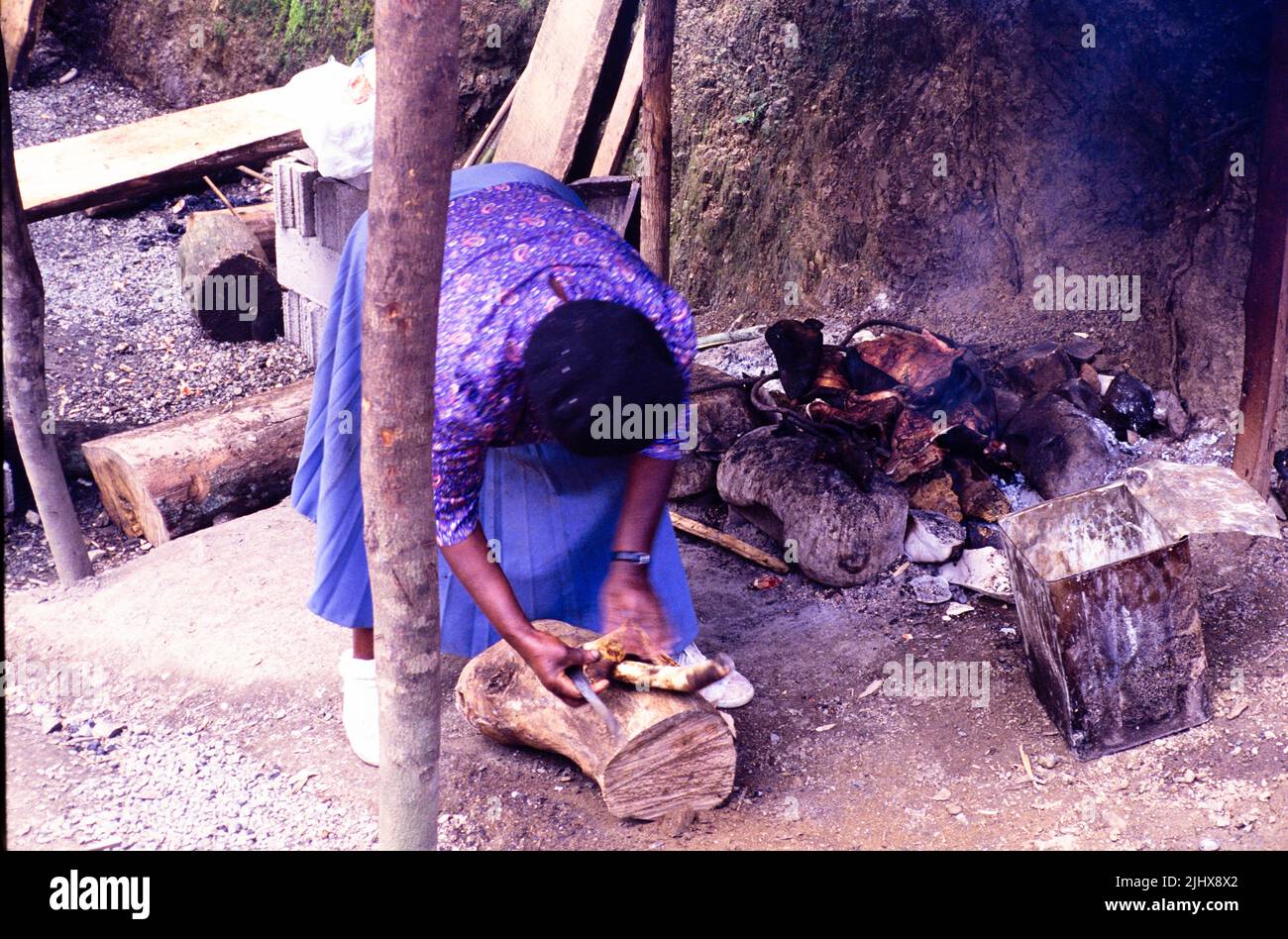 Femme qui bécoie des produits de viande sur feu ouvert Spalding, paroisse de Clarendon, Jamaïque, Antilles, 1990 Banque D'Images