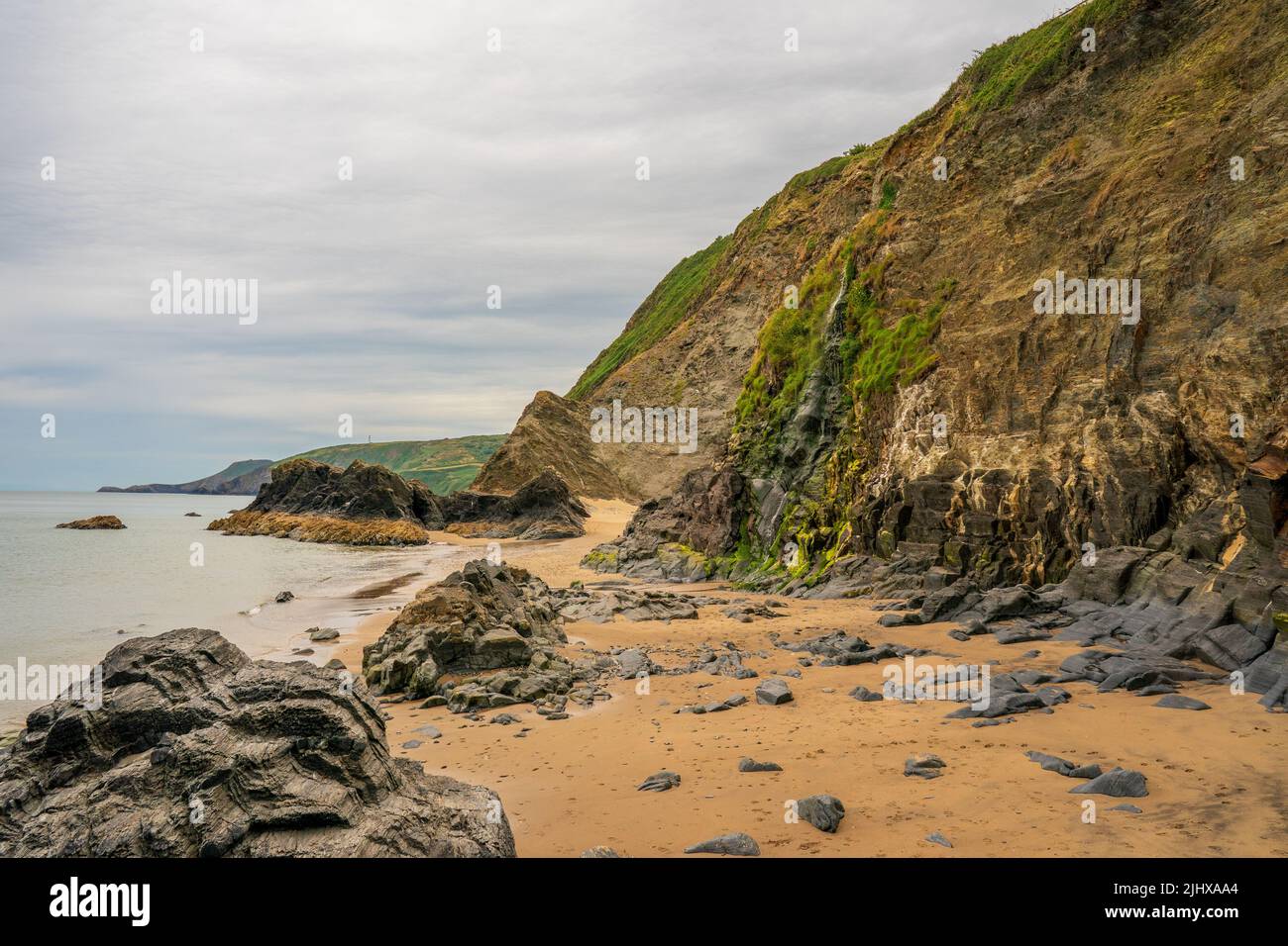 Cascade de plage et formations rocheuses à Tresaith Ceredigion West Wales Royaume-Uni Banque D'Images