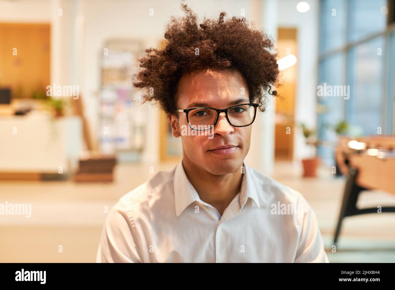 Jeune homme africain comme entrepreneur de démarrage avec la coiffure d'afro dans son bureau Banque D'Images