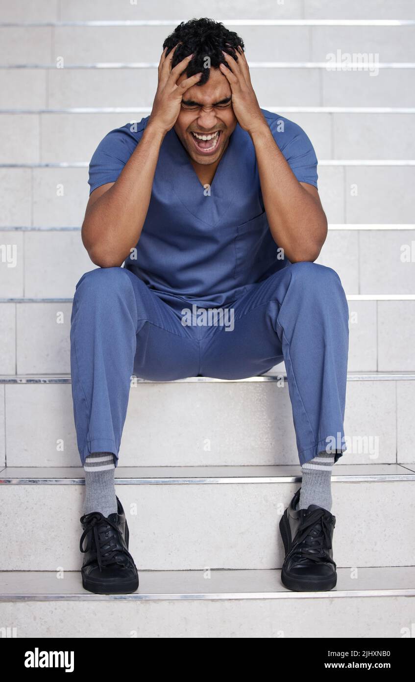 Il est peut-être temps de passer des vacances. Un jeune médecin hurle alors qu'il travaillait dans un hôpital moderne. Banque D'Images