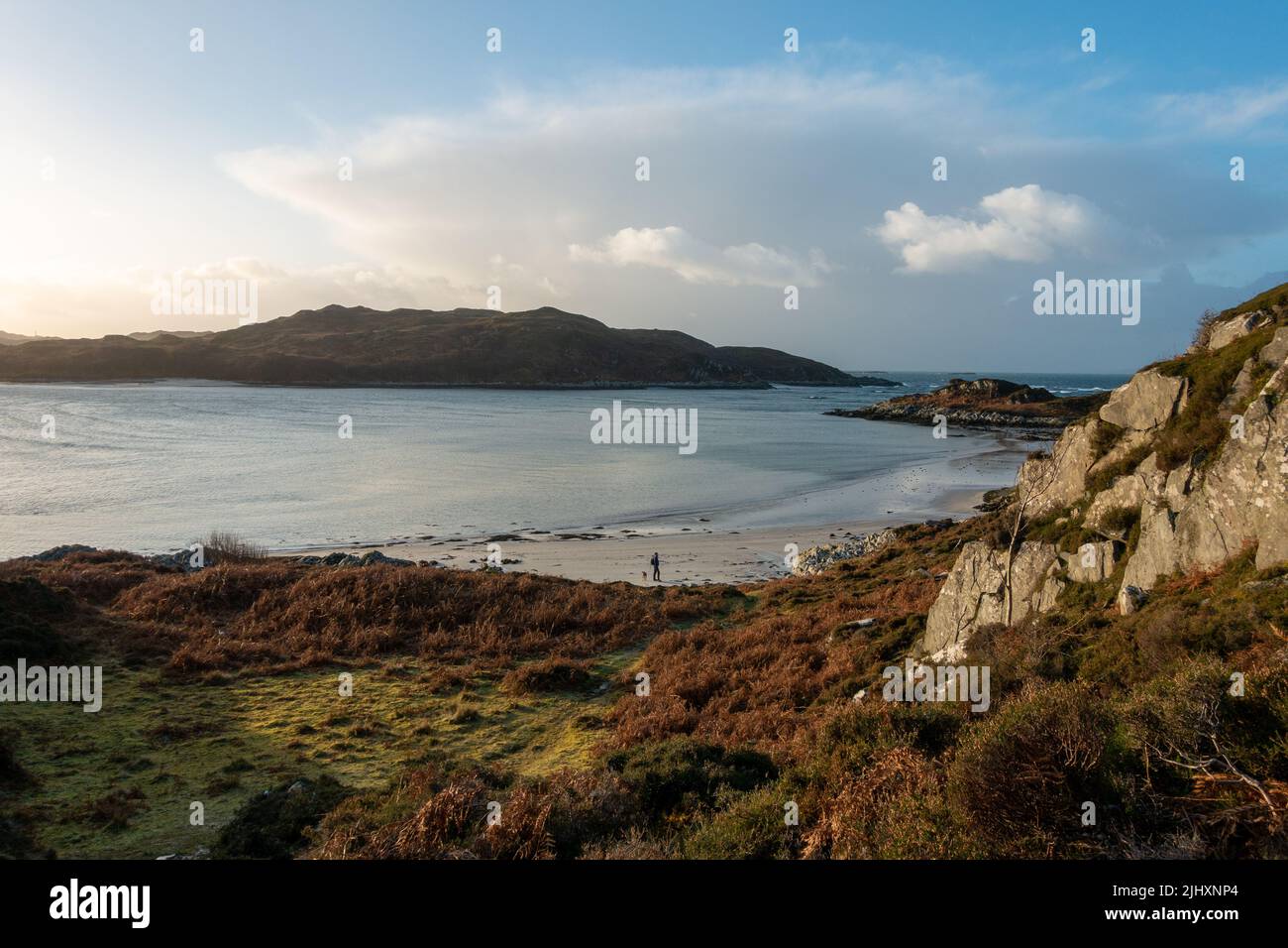 Paysage écossais : plage de Bourblach près de Morar avec promeneur solitaire et chien sur les sables, Écosse Banque D'Images