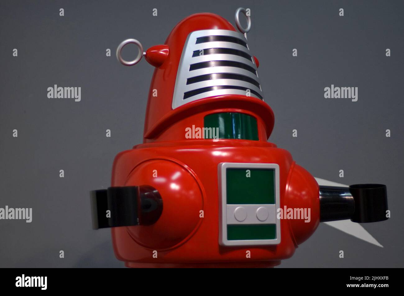 Gros plan d'un robot rouge de science-fiction rétro-futuriste sur fond gris Banque D'Images