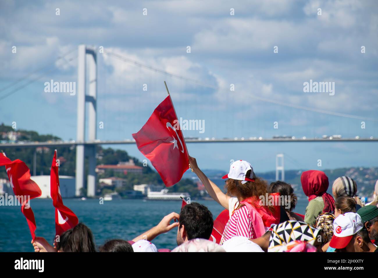 Istanbul, Turquie - juillet 2022: Jeune fille portant le drapeau turc et ceux qui l'entourent. Les gens agitant le drapeau turc sur le navire. Banque D'Images