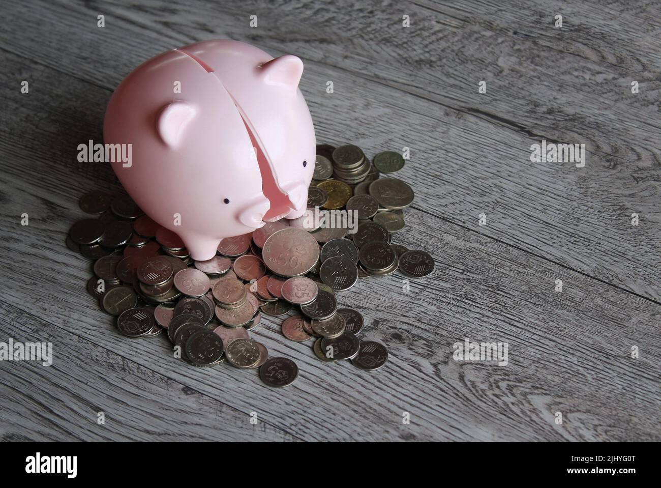 Banque de porc cassée et pièces de monnaie sur table en bois avec espace de copie. Concept financier. Banque D'Images