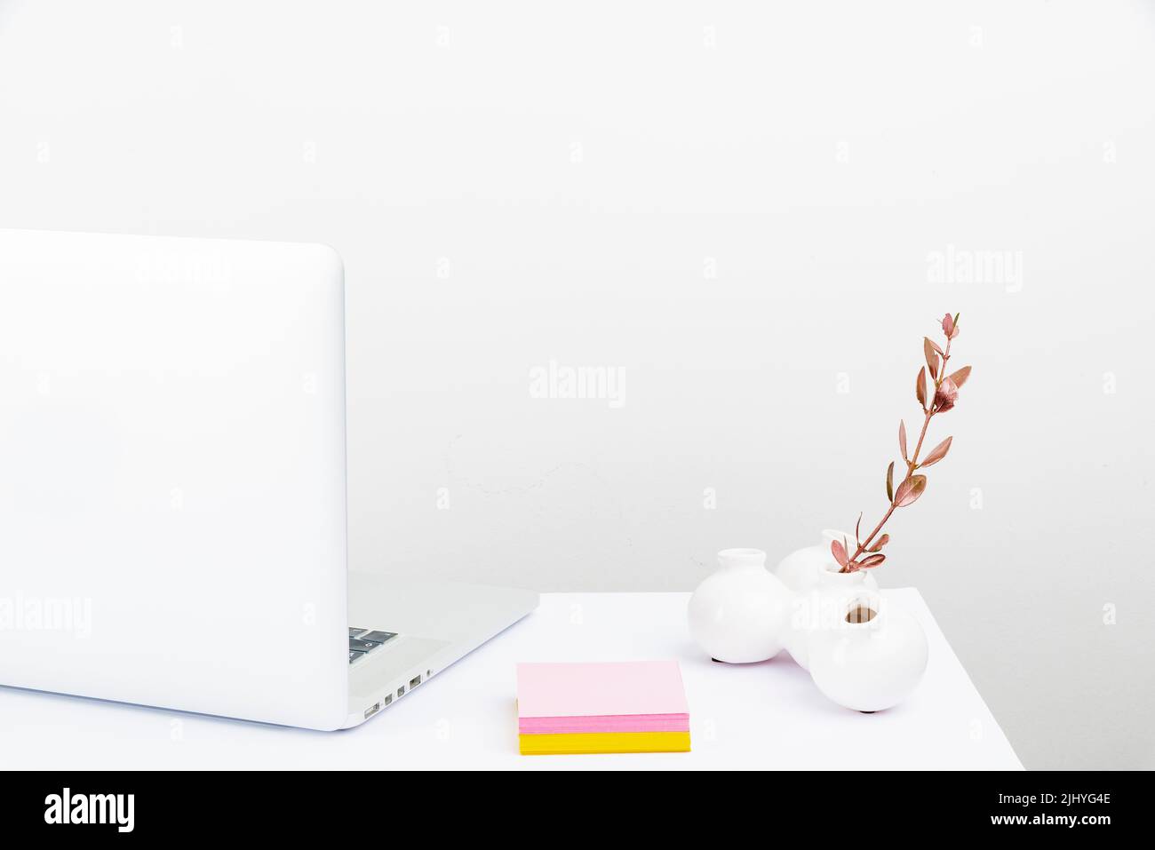 Un espace de travail bien rangé avec un ordinateur portable blanc Banque D'Images