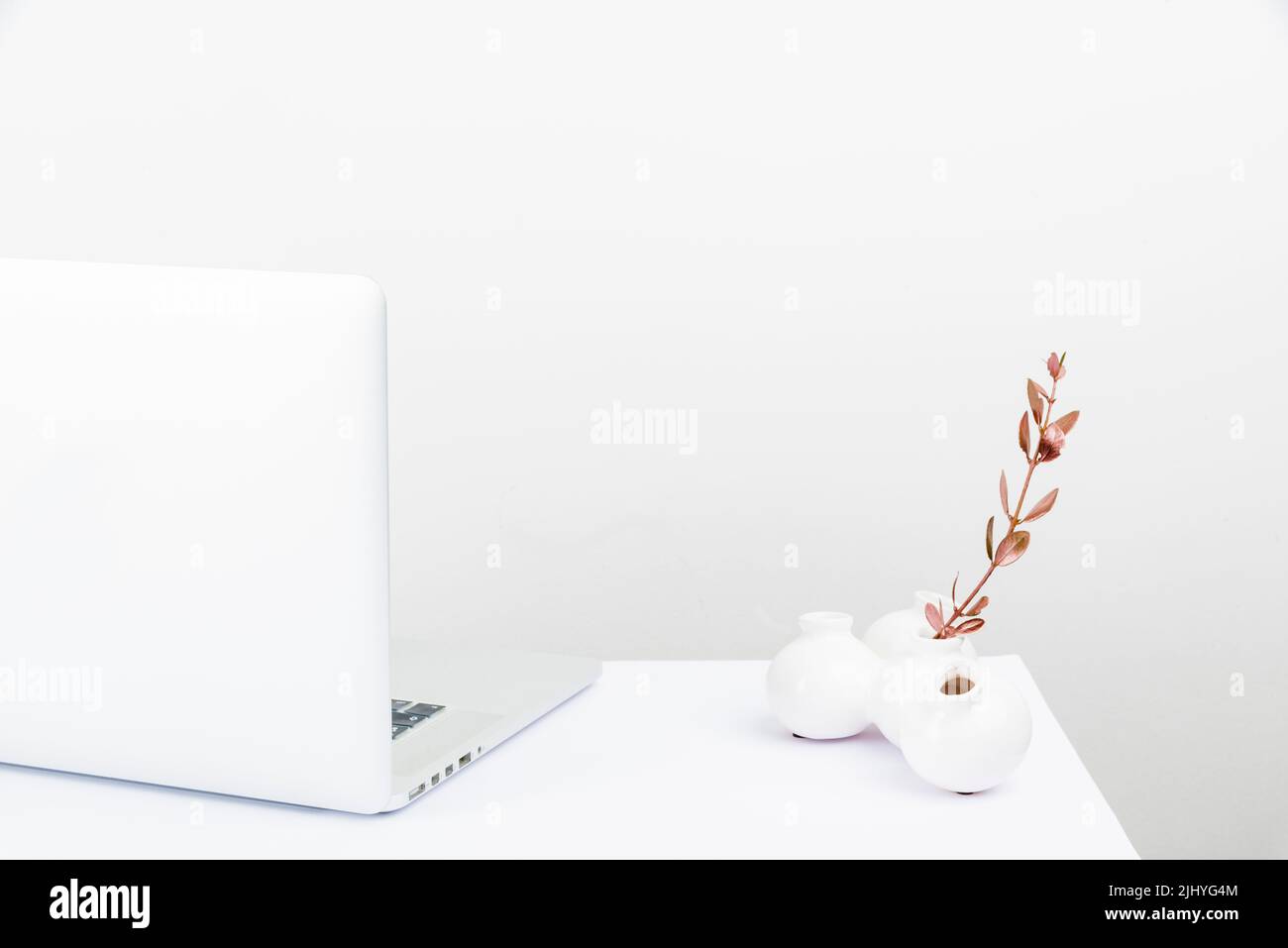 Un espace de travail bien rangé avec un ordinateur portable blanc Banque D'Images