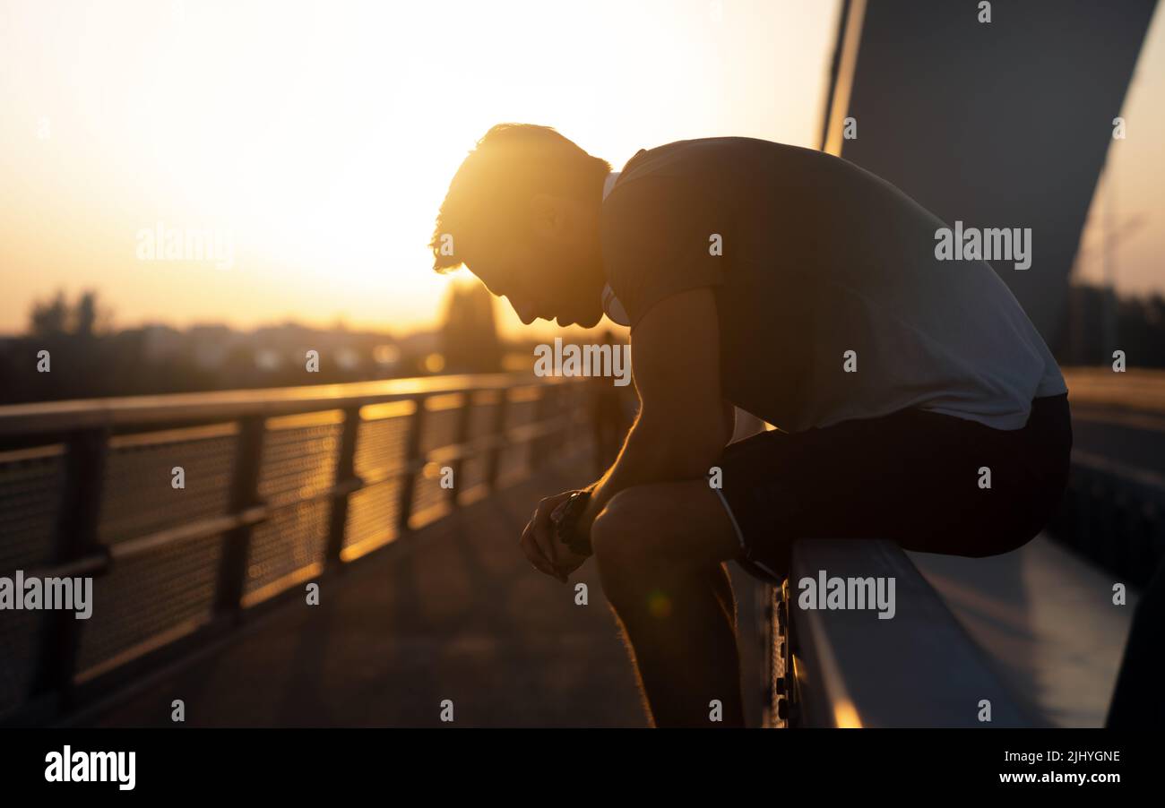 Un jeune homme en forme fait une petite pause après un entraînement en plein air.Fitness sport personnes concept de style de vie Banque D'Images