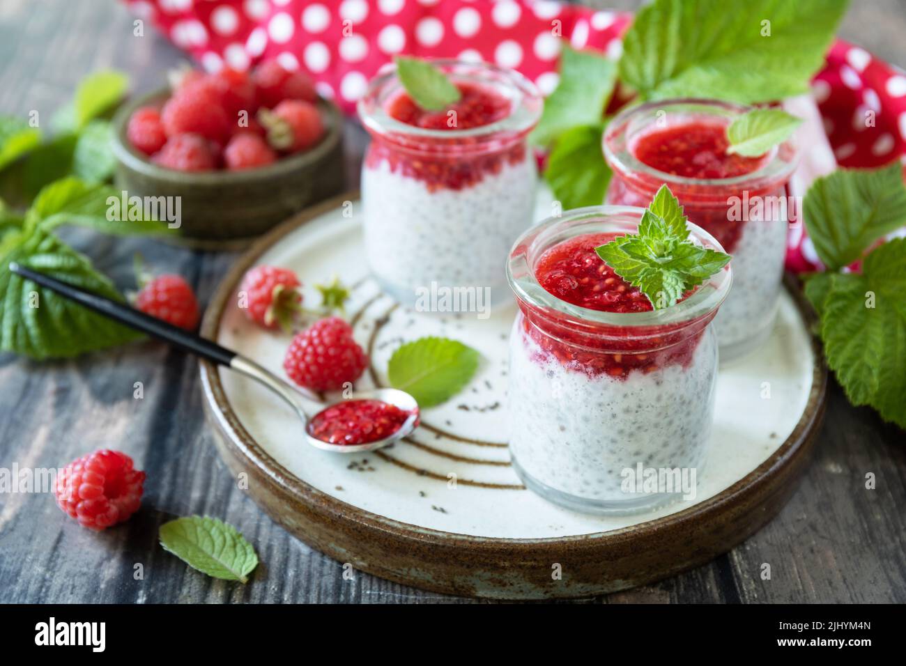 Petit déjeuner sain. Pots en verre avec pudding au chia à la framboise et à la confiture ou smoothies aux graines de chia sur table rustique. Banque D'Images
