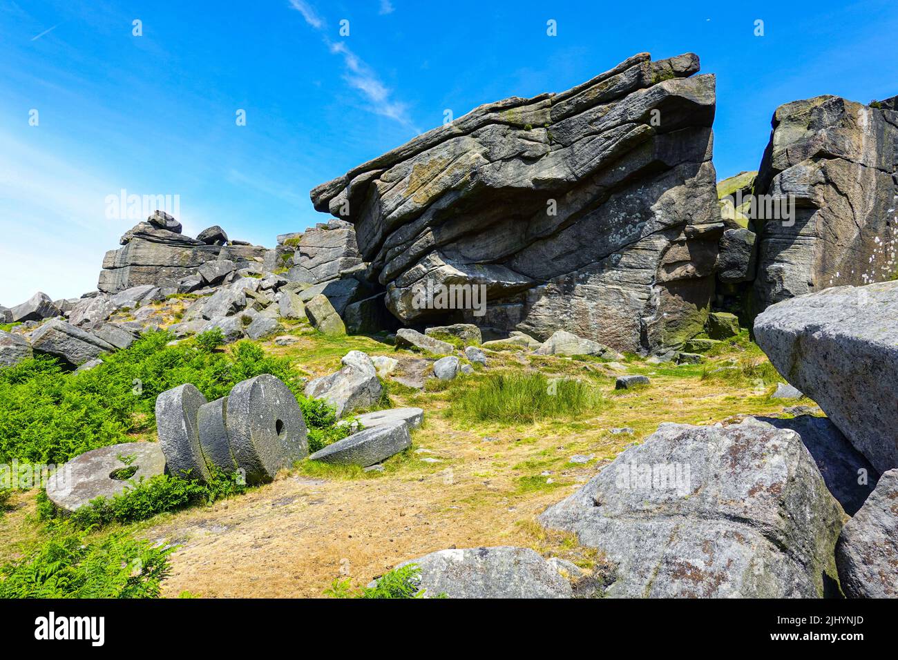 Pierres de moulin abandonnées sous Stanage Edge, falaise de pierre à aiguiser, parc national de Peak District, Derbyshire, Royaume-Uni Banque D'Images