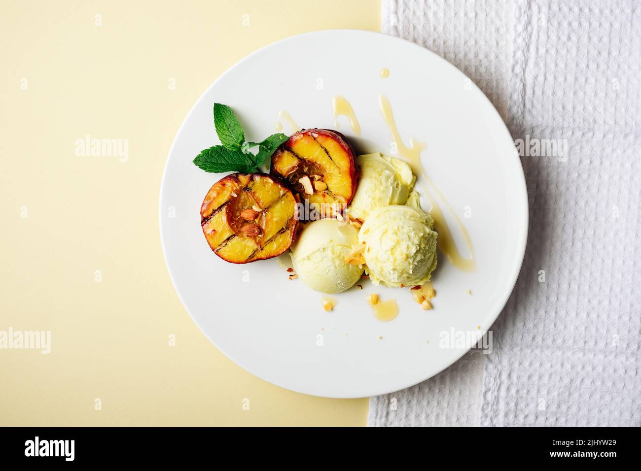 Pêches grillées et crème glacée au citron avec du miel. Banque D'Images