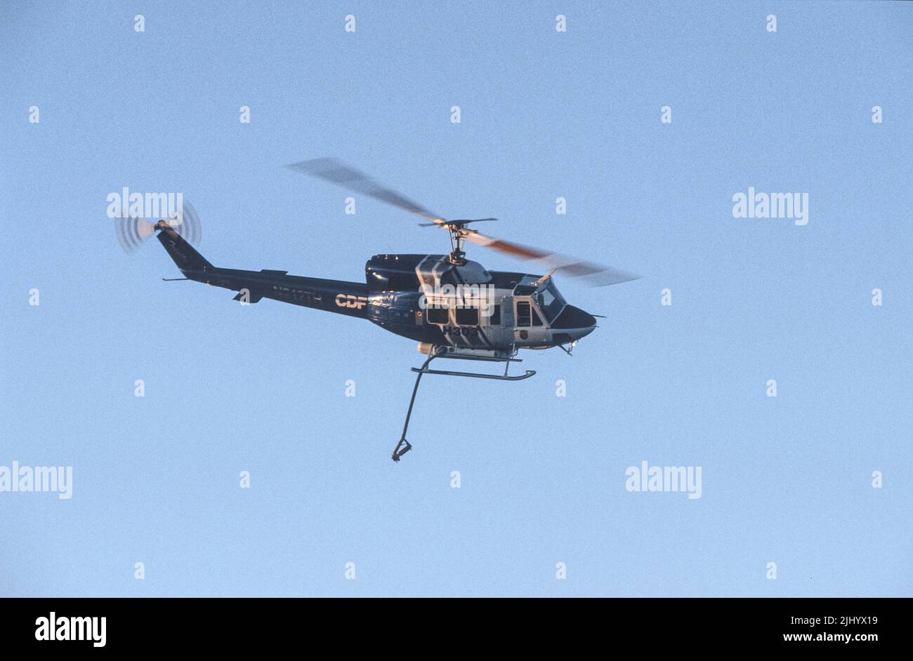 L'hélicoptère H303 du Département des forêts de la Californie fait le tour de la zone de chute avant de faire une goutte d'eau sur un feu de broussailles Banque D'Images