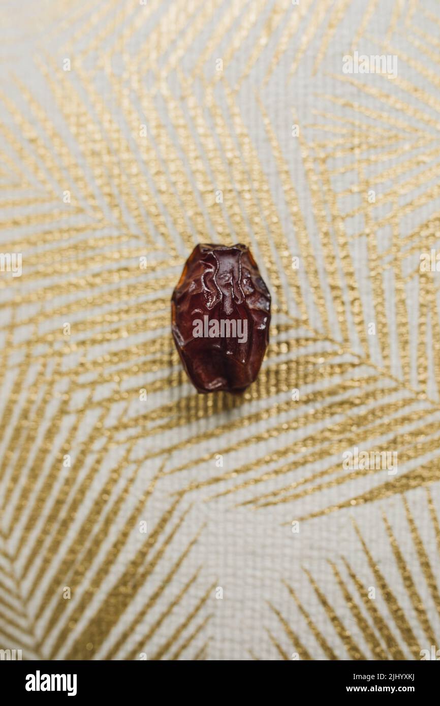 fruit unique sur un tissu doré à imprimé palmiers Banque D'Images