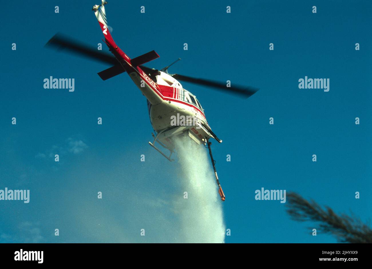 L'hélicoptère régional de secours incendie de San Diego de Kachina aviation fait une goutte d'eau sur un feu de forêt (brosse) en fonctionnement. Banque D'Images