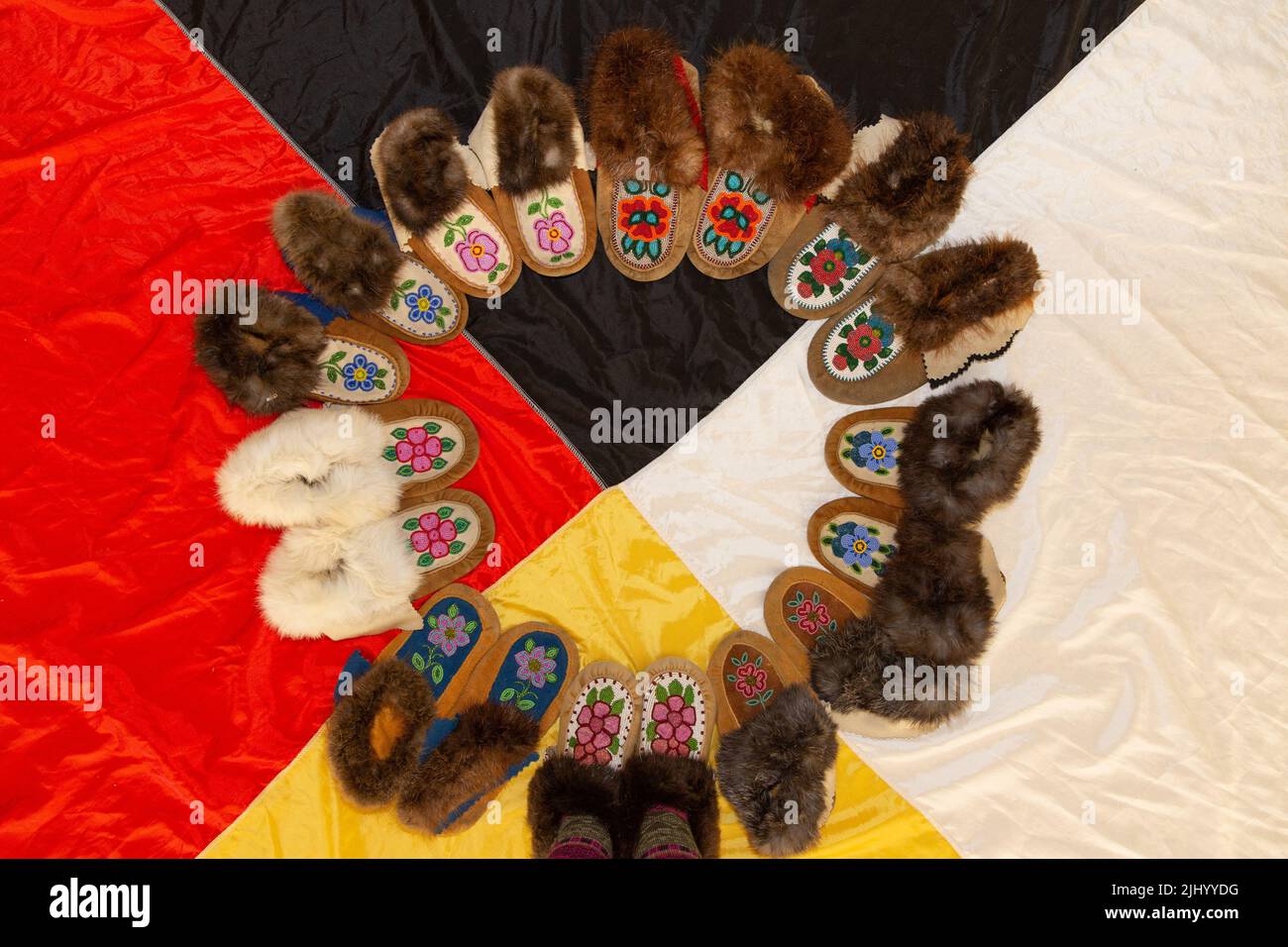 Une collection de pantoufles de mooshide à perles indigènes traditionnelles placées au-dessus du drapeau de la roue de médecine, Yellowknife, Territoires du Nord-Ouest, Canada. Banque D'Images