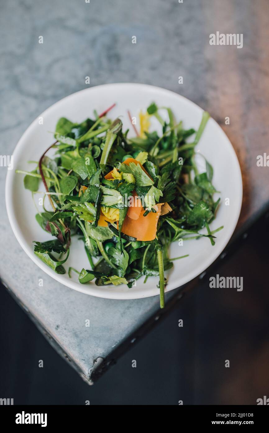 Salade de cresson sauvage avec petits pois et mimolette d'orange Banque D'Images