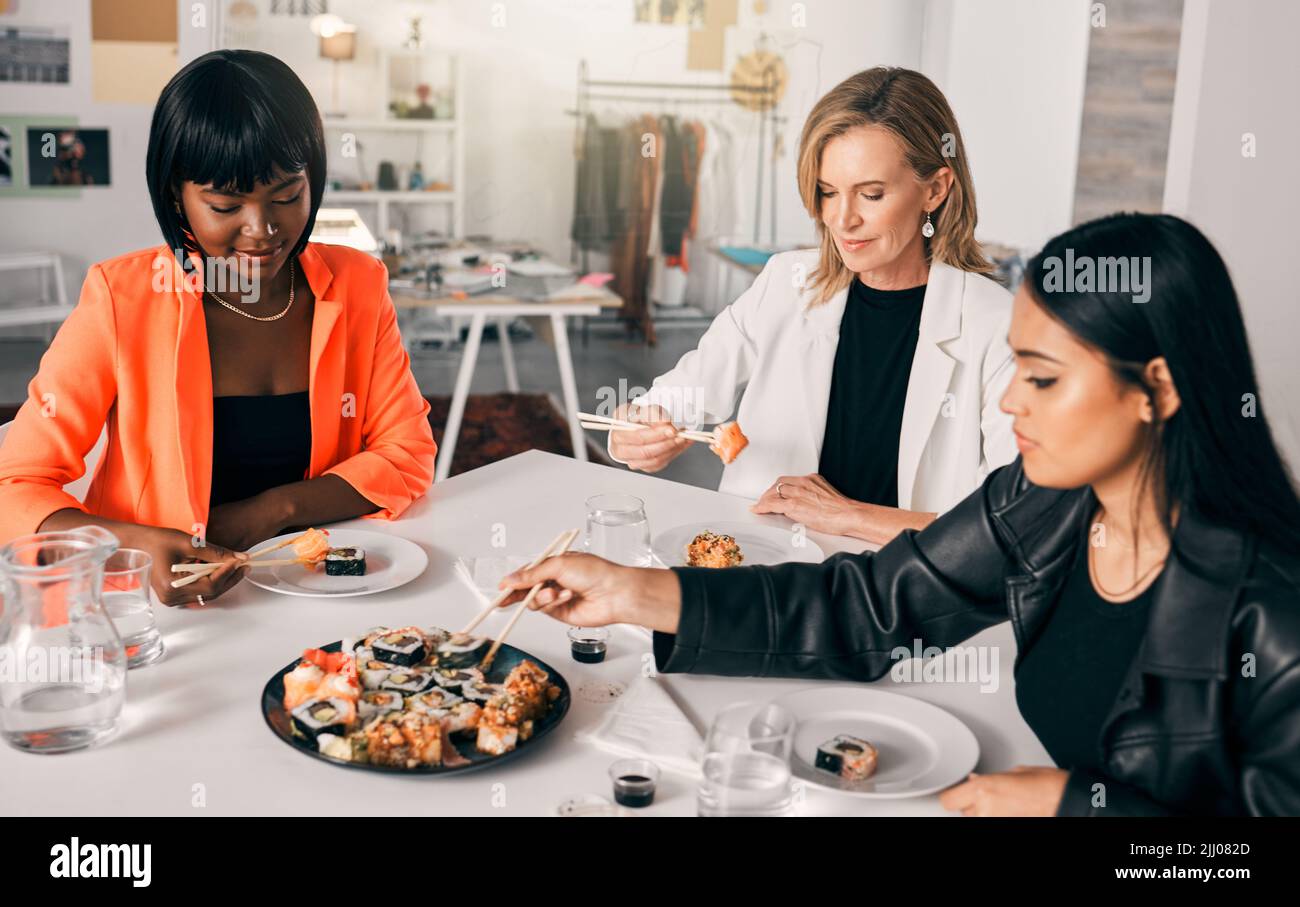 La nourriture rassemble les gens. Un groupe d'amis de sexe féminin qui déguste des sushis. Banque D'Images