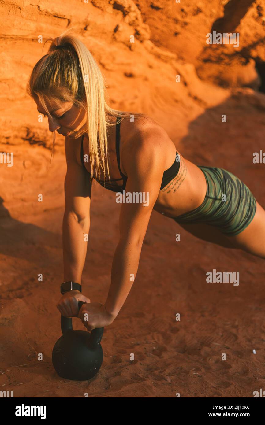 Jeune femme faisant de l'exercice crossfit en plein air dans le désert surro Banque D'Images