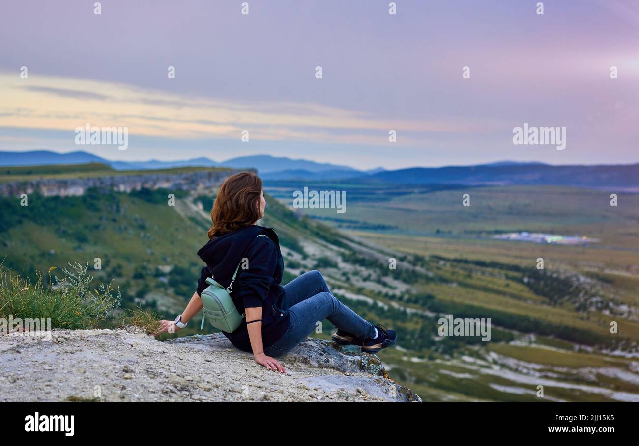 la fille est assise au sommet d'une montagne Banque D'Images