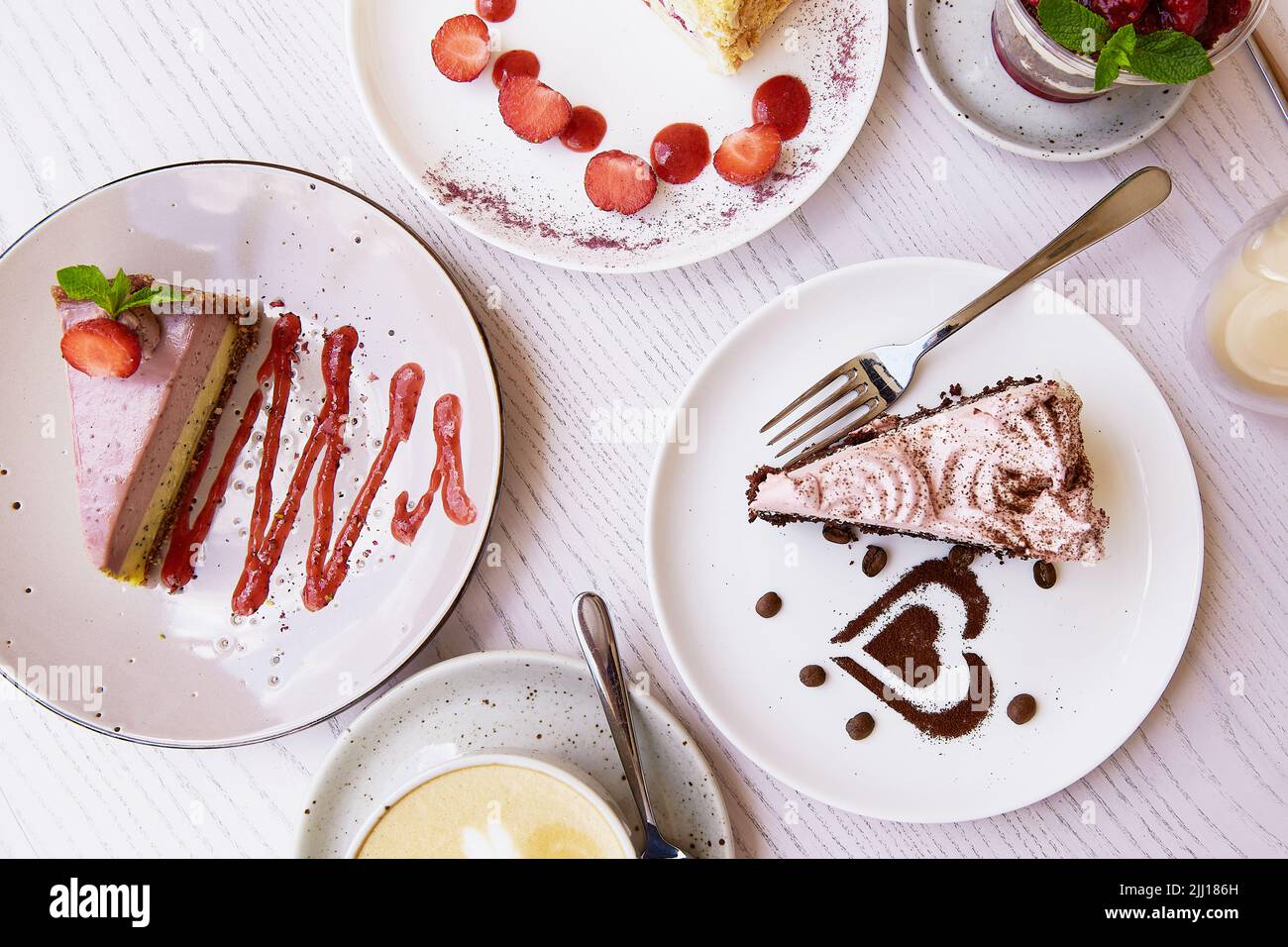 Assortiment de légumes naturels, desserts superposés, gâteaux aux fruits frais et baies au café. Célébration, assortiment de gâteaux sur la terre cuite Banque D'Images