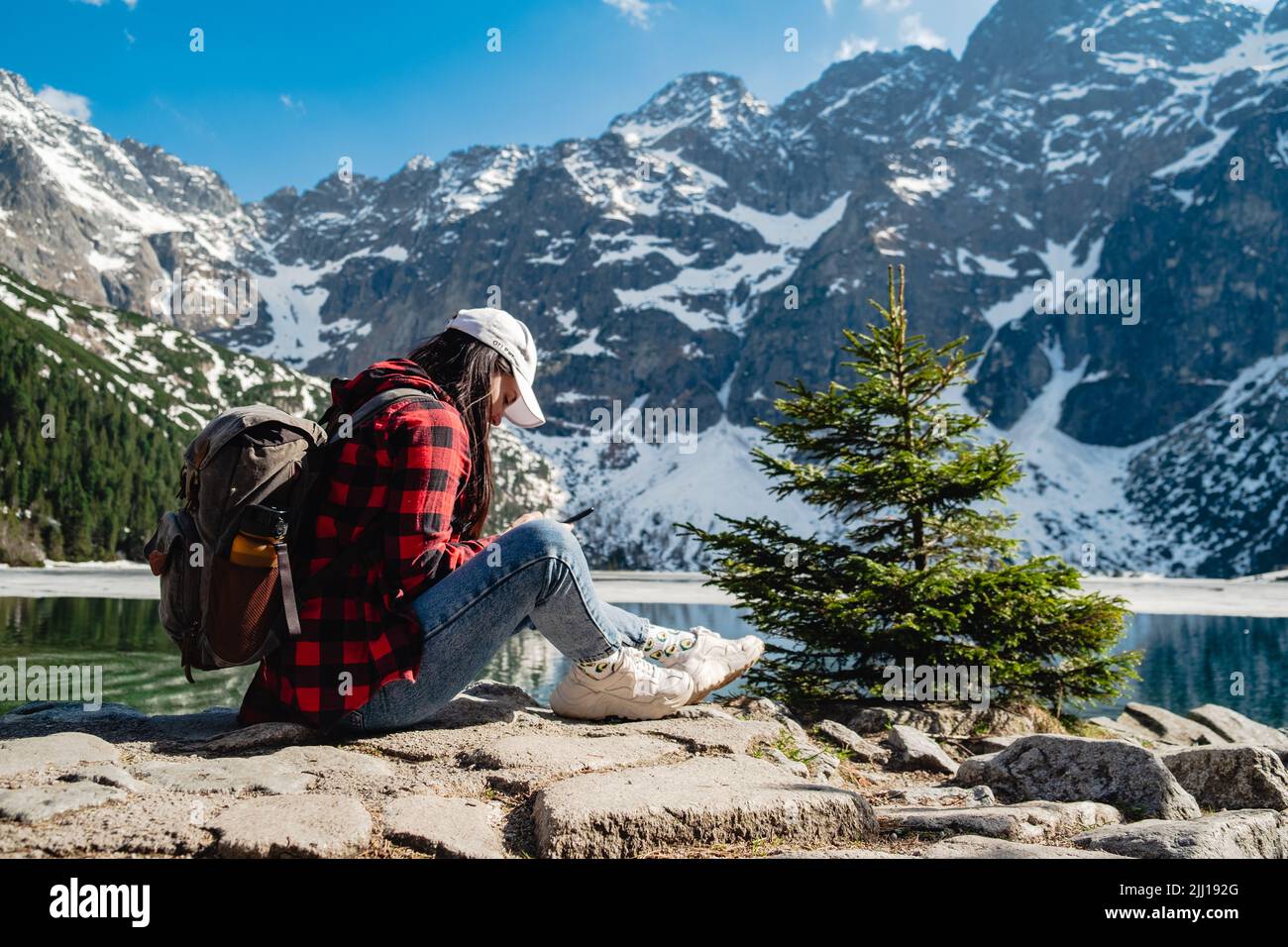 Une femme est assise sur la rive d'un lac. Morskie Oko, montagnes Tatras. Banque D'Images