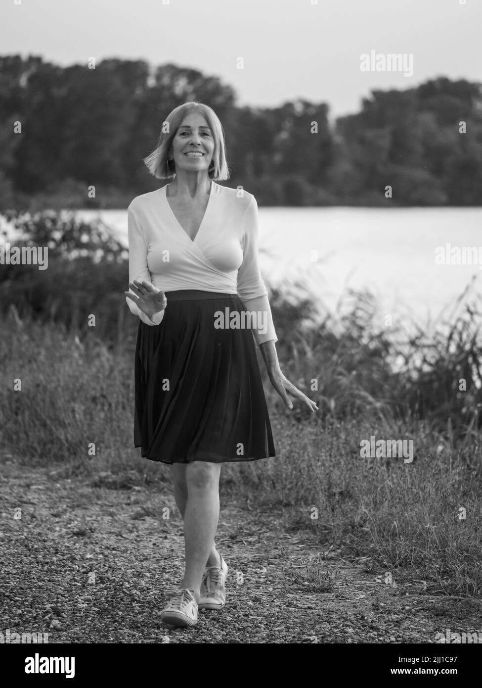 senior tenue élégante dame habillé blaka dn blanc portant des lunettes de soleil appréciant la nature en été Banque D'Images