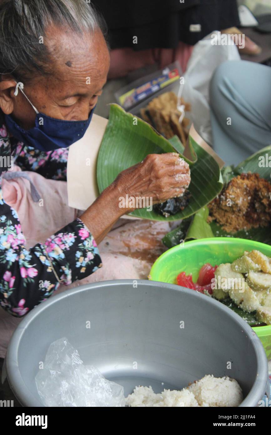 Indonésien Street Food à Yogyakarta, Mbah Satinem, vendant jajanan traditionnel Javanese Street Food Ketan, Lupuis, Cenil près de Tugu, Yogyakarta Banque D'Images