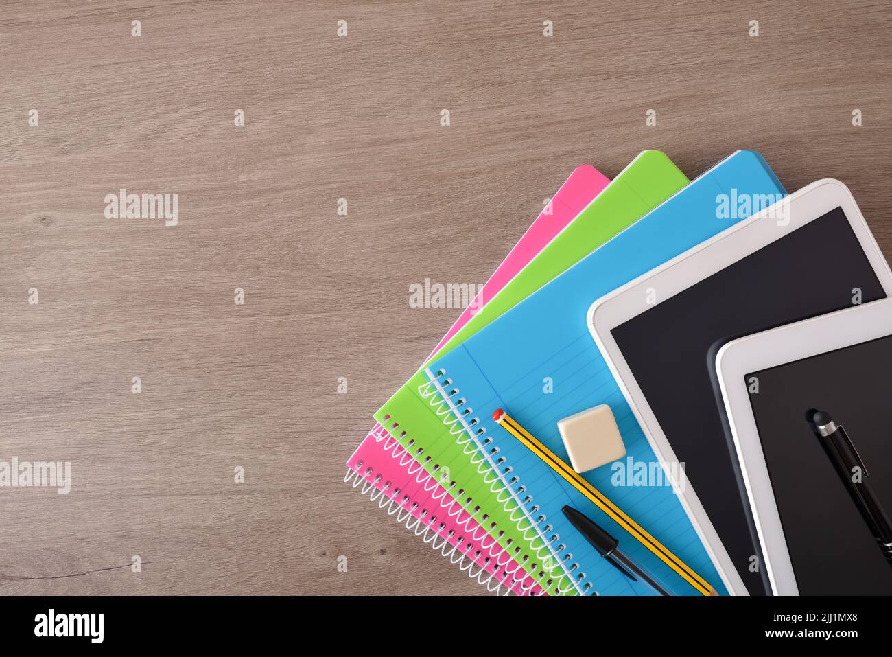 Concept d'apprentissage scolaire avec livres électroniques sur des carnets papier sur un bureau en bois. Vue de dessus Banque D'Images