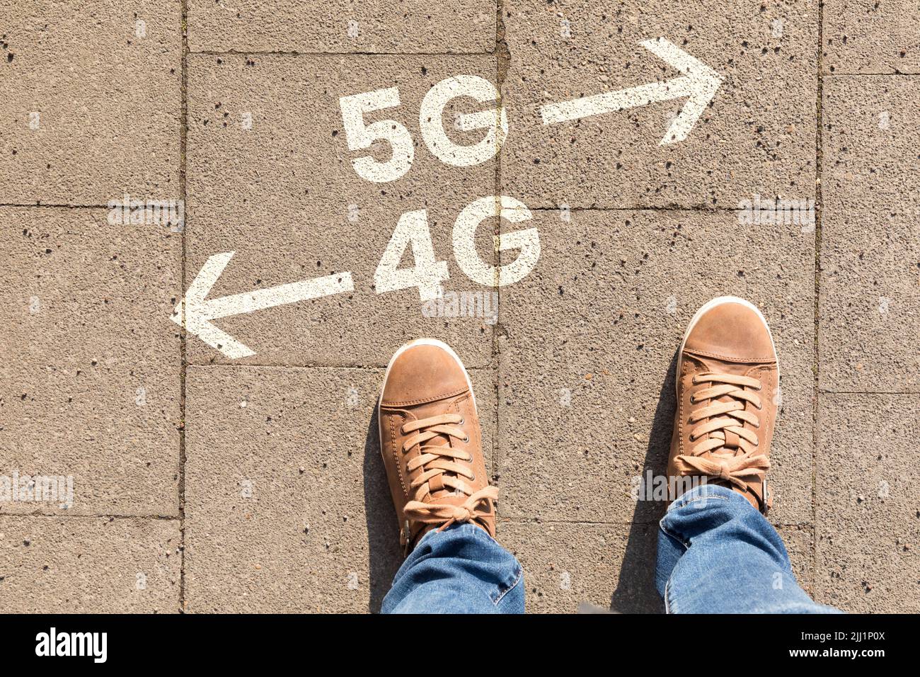 Chaussures marron avec texte indiquant les directions vers 4G ou 5G sur un sol Banque D'Images