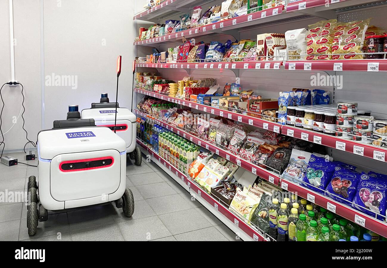 Moscou, Russie, mars 2022 : deux robots de livraison de colis et de marchandises font payer de la nourriture à partir d'un point de vente dans un bureau de poste à côté des étagères. PA express Banque D'Images