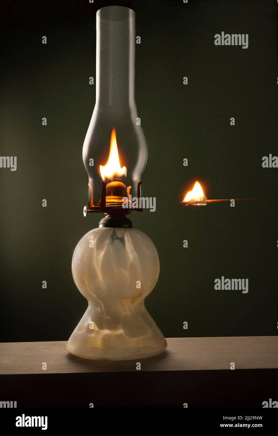 Lampe à huile avec bol en verre et allumette éclairée Banque D'Images