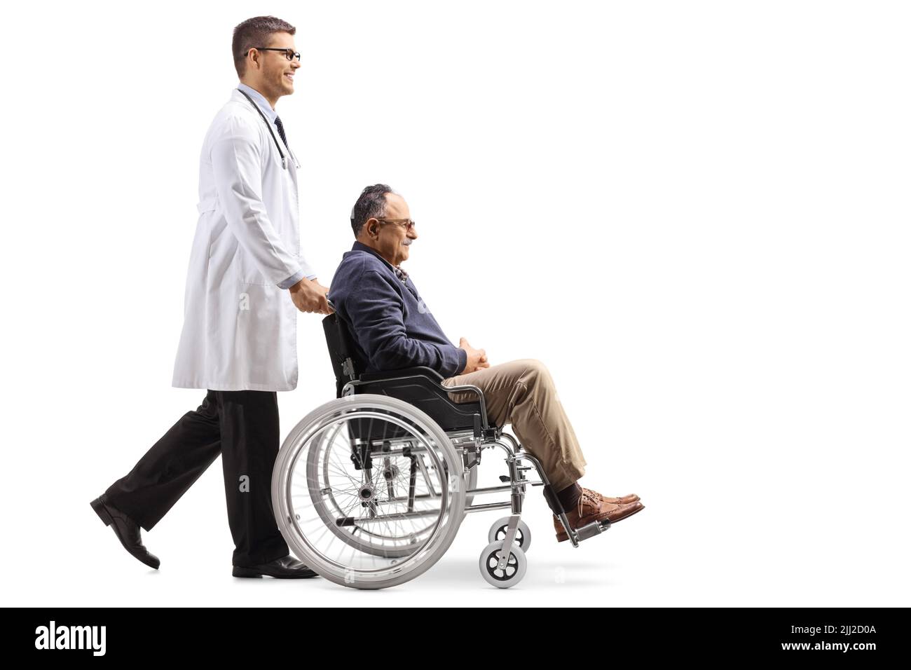 Prise de vue en profil d'un médecin marchant et poussant un homme mûr dans un fauteuil roulant isolé sur fond blanc Banque D'Images