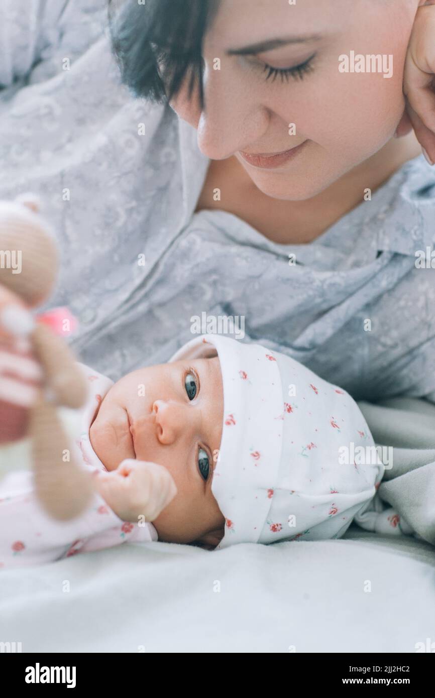 la mère joue avec son nouveau-né un jouet ours en peluche Banque D'Images