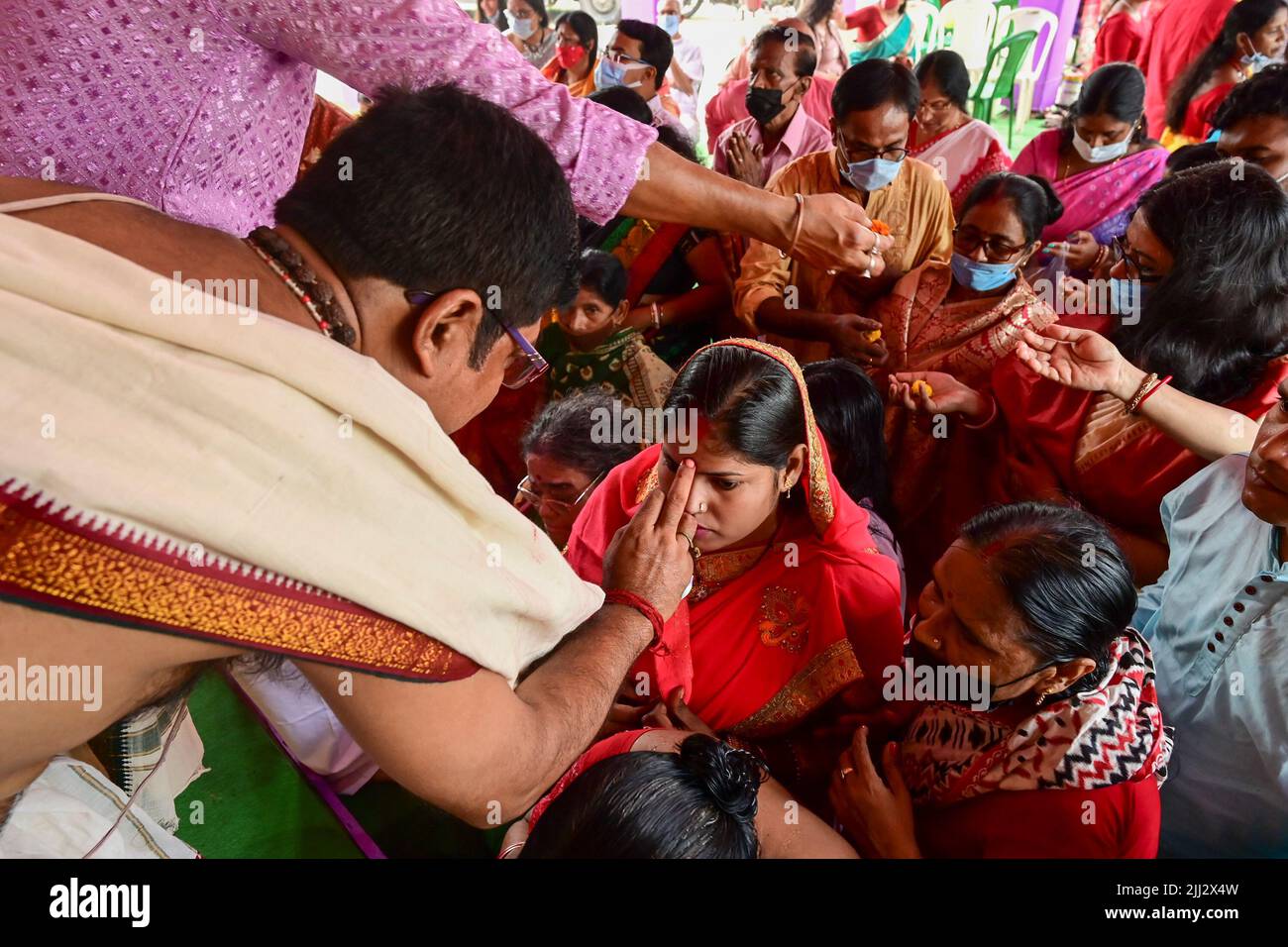 Howrah, Bengale-Occidental, Inde - 14th octobre 2021 : Hindu Purohit mettant le tilak Saint sur les fronts des dévotés pendant puppanjali puja à la déesse Durga. Banque D'Images