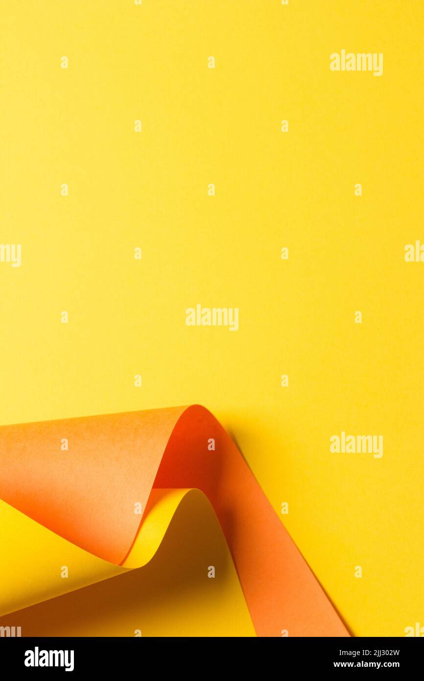 Papier de couleur jaune et orange courbe et géométrique avec lumière et ombres. Arrière-plan de géométrie abstraite avec espace de copie Banque D'Images