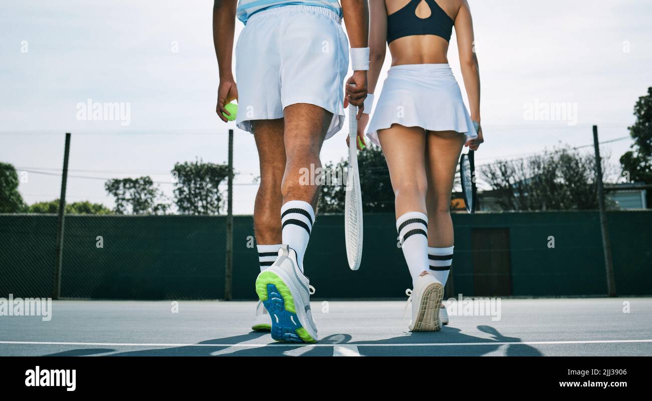 Un jeu bien joué. Deux joueurs de tennis méconnaissables s'éloignent après un match. Banque D'Images