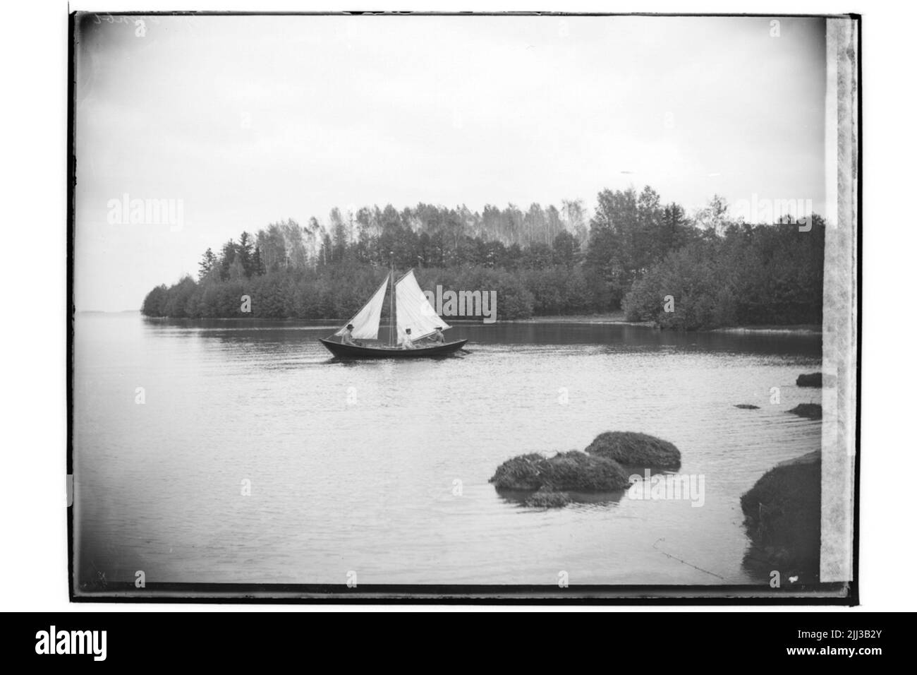 Bateau à voile (Hjälmersnipa) et 3 personnes.Aug Larsson Banque D'Images