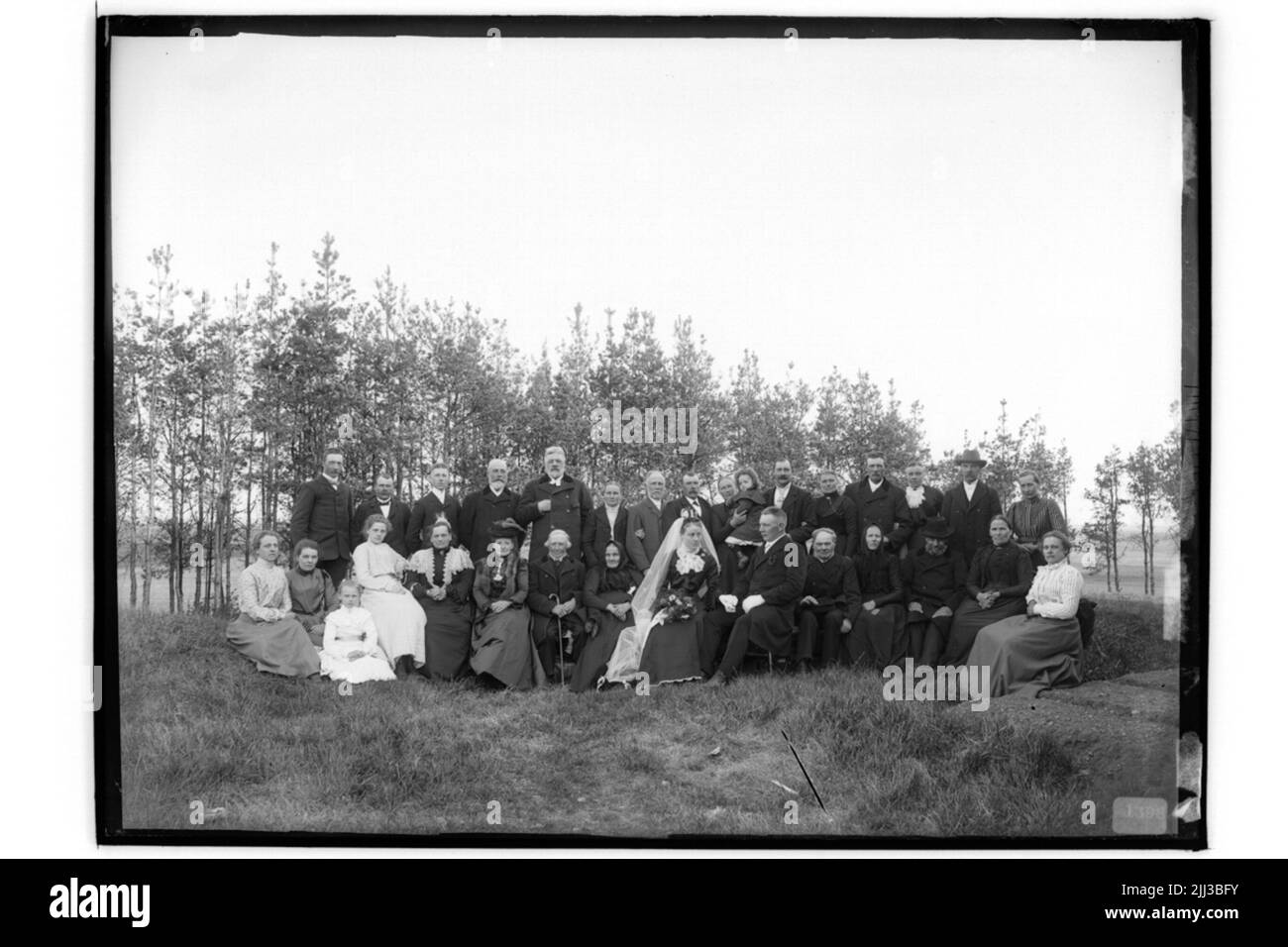 Mariage. 31 personnes. La mariée en robe noire, voile blanc et couronne, le marié en manteau.Johan Karlsson Banque D'Images