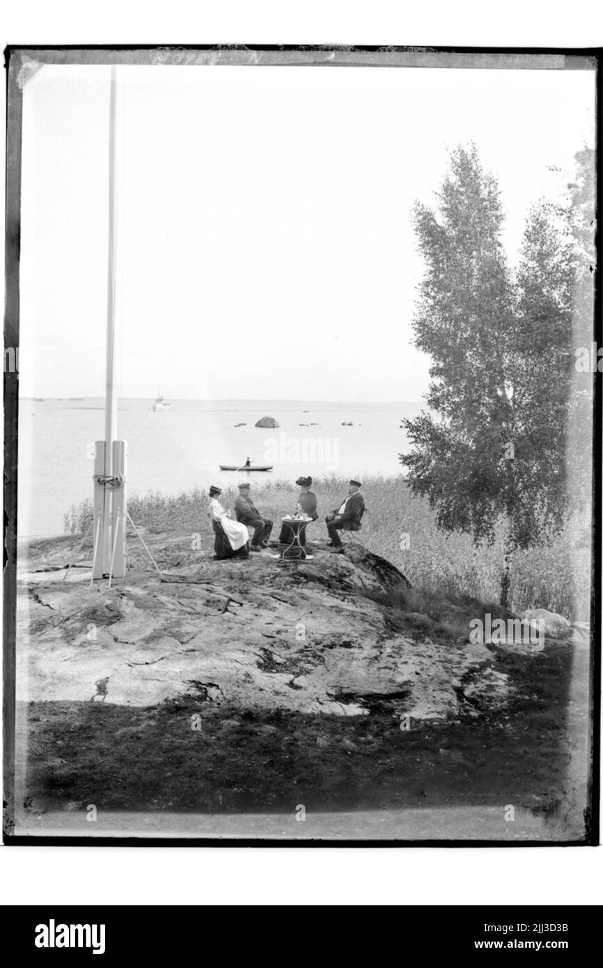 Motifs d'été, 4 personnes. Mer et bateau à moteur en arrière-plan. Barmer P.O. Jonsson, Drottninggatan 10, Örebro. Banque D'Images