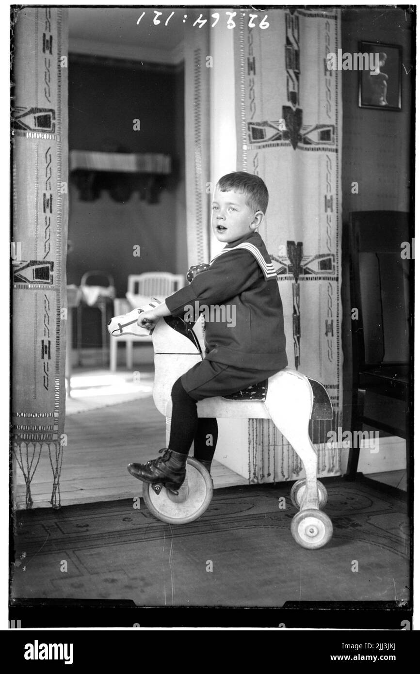 Hålahult sanatorium, intérieur, garçon habillé en costume de marin sur un cheval en bois avec roues. Banque D'Images