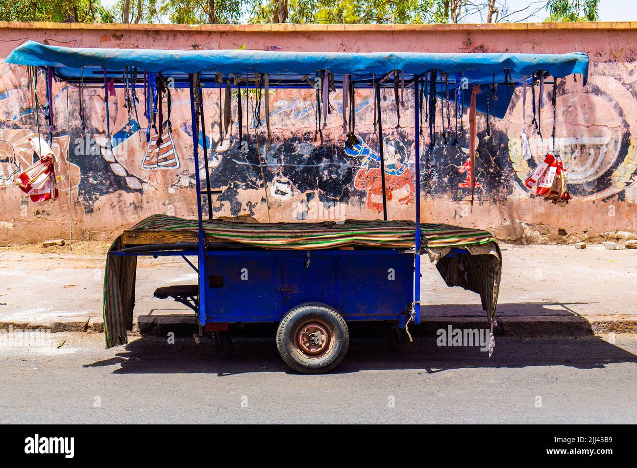Marrakech, Maroc - 10 juillet 2022 : une vieille charrette devant un vieux mur peint Banque D'Images