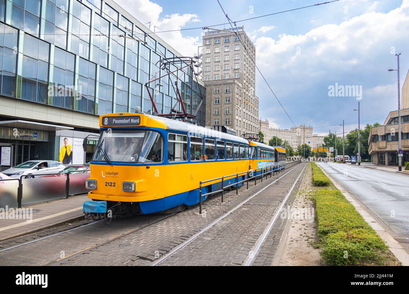 Leipzig, Allemagne - 25 juin 2022 : tramway de Leipzig à l'arrêt Augustusplatz. Le vieux tramway de la ville, aux couleurs bleu et jaune, s'arrête à un arrêt de tramway. Les gens obtiennent Banque D'Images