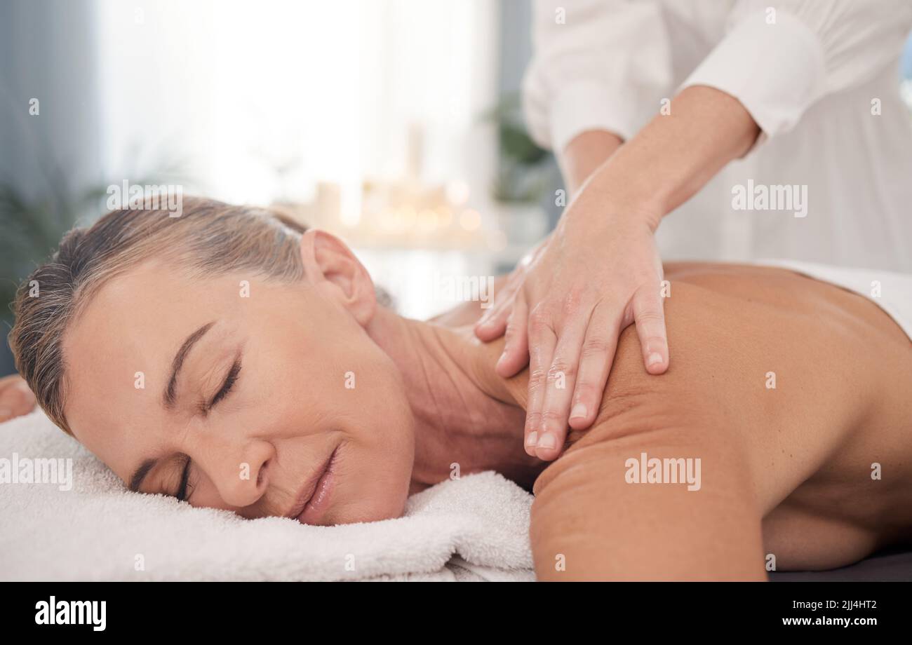 Respirez profondément et mettez votre bien-être en premier. Femme adulte bénéficiant d'un massage relaxant du dos au spa. Banque D'Images