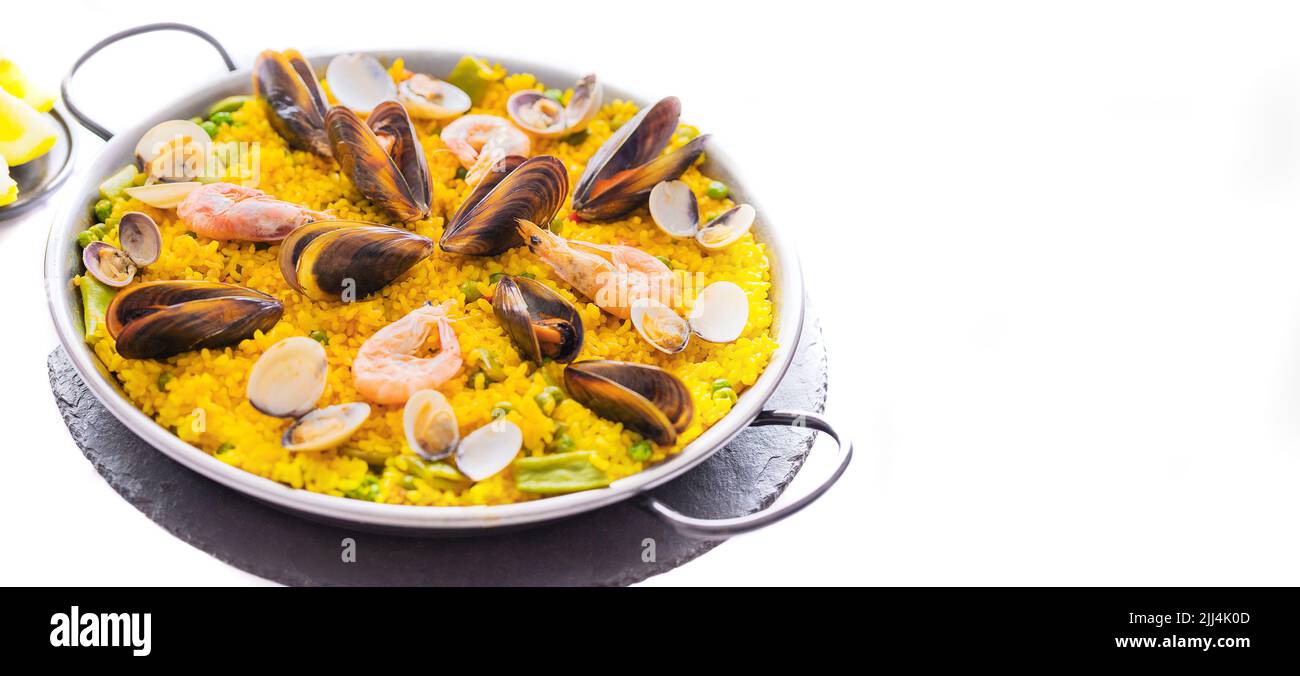 Paella de fruits de mer aux crevettes, palourdes et moules sur riz au safran avec légumes servis dans une poêle traditionnelle. Cuisine espagnole vaste fond. C Banque D'Images