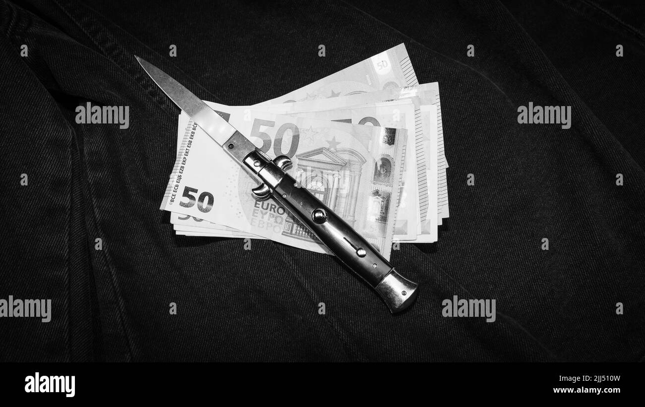 Couteau italien et quelques billets en euros, photo monochrome Banque D'Images