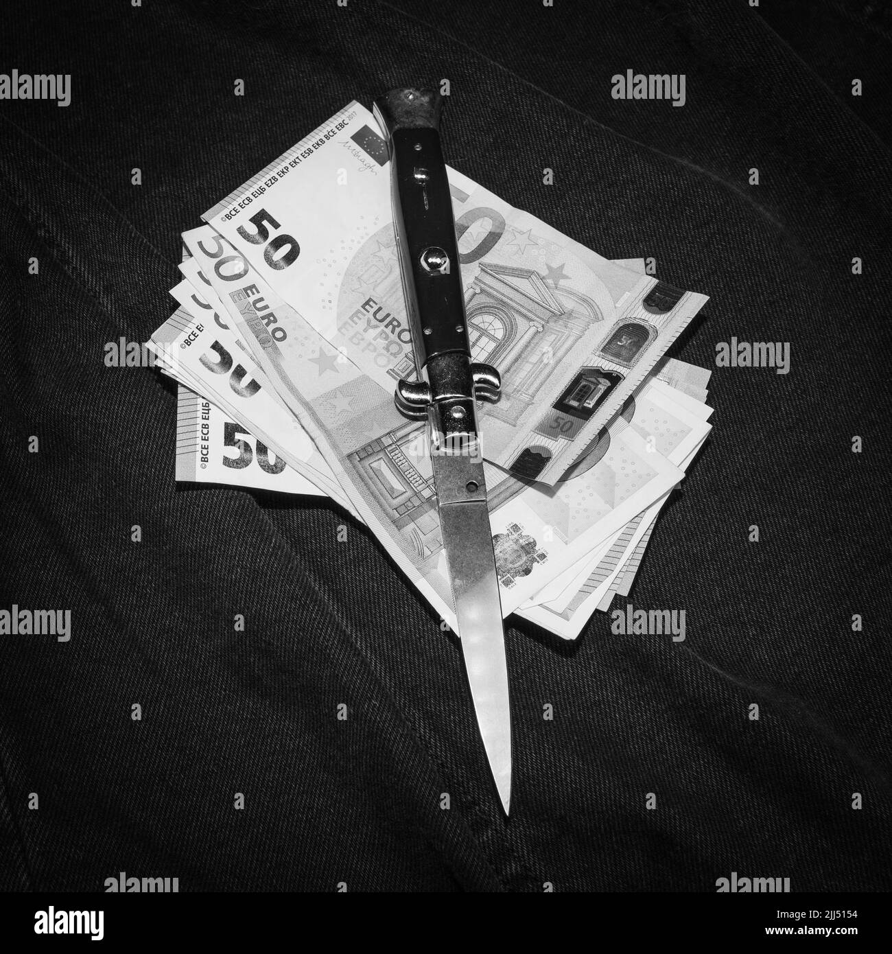 Couteau italien et quelques billets (euro), photo monochrome Banque D'Images