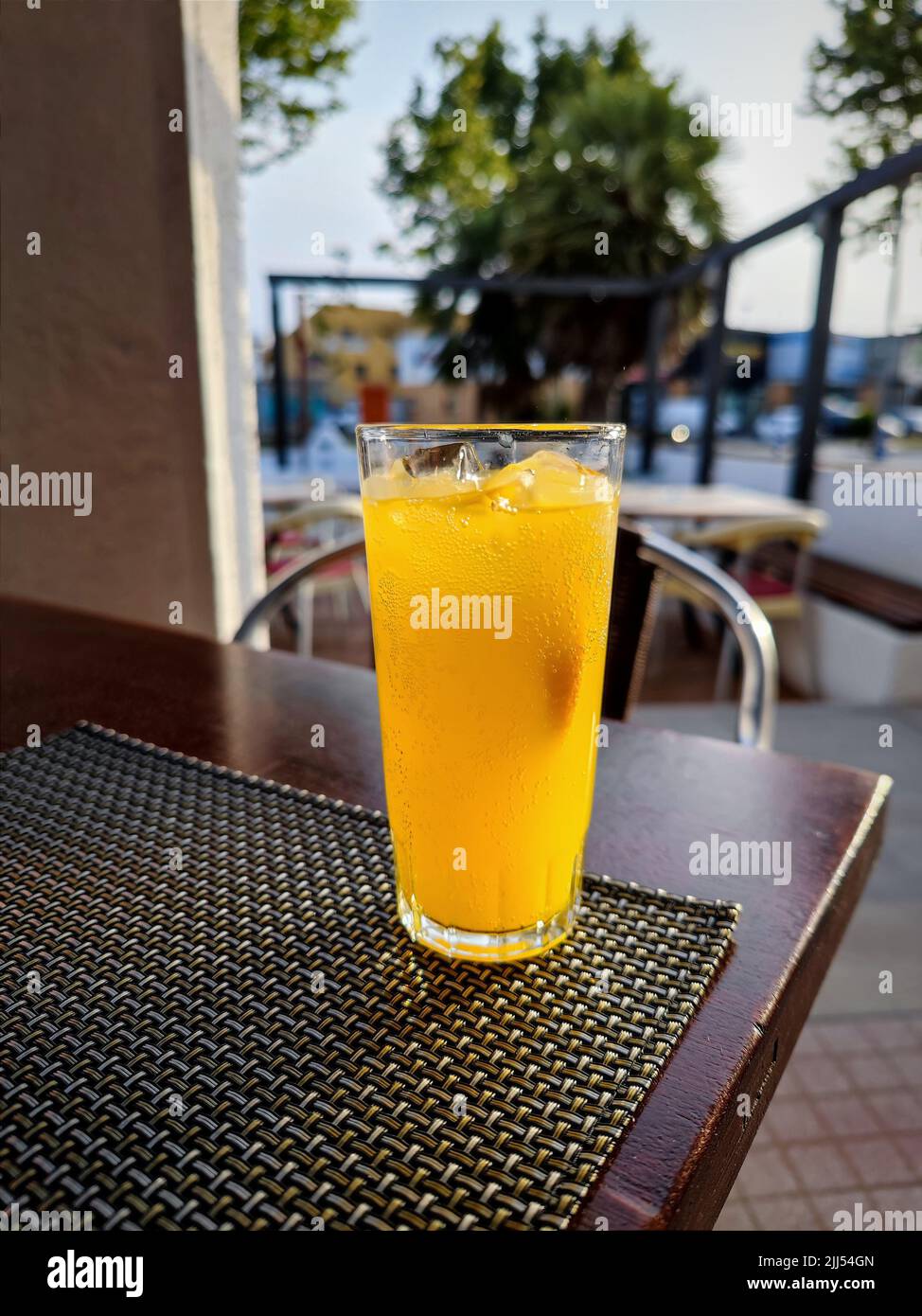 Belle boisson froide au soda jaune d'orange sur une table en terrasse Banque D'Images